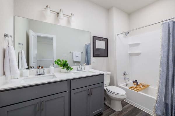 Modern bathroom featuring sleek fixtures and marble countertop at Caso University Heights Apartments