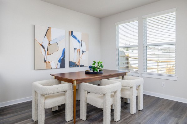 Dining area with modern decor at Caso University Heights Apartments: Elegant setup with wooden table and pendant lighting