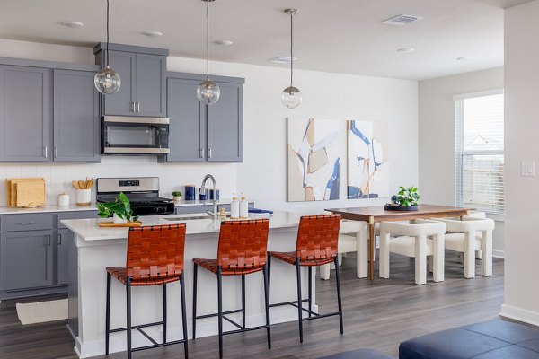 Kitchen showcasing sleek counters and modern appliances in Caso University Heights Apartments