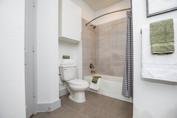 Modern bathroom with sleek vanity and soaking tub at The Madison at City Place Apartments