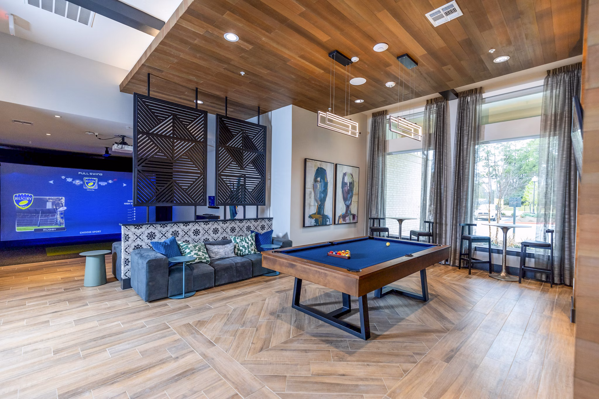 Modern clubhouse game room with pool table and cozy seating at The Madison at City Place Apartments