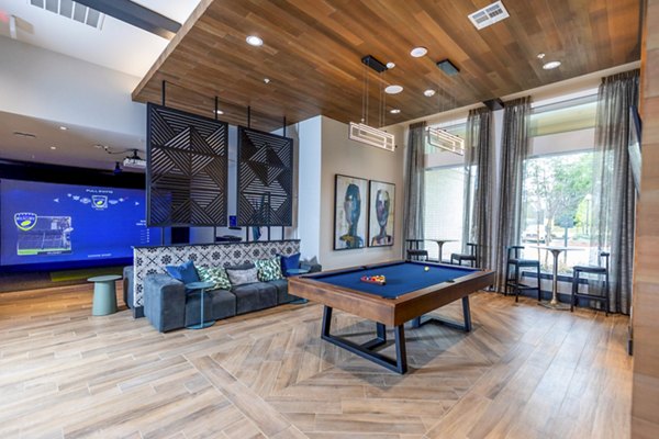 Modern clubhouse game room with pool table and cozy seating at The Madison at City Place Apartments