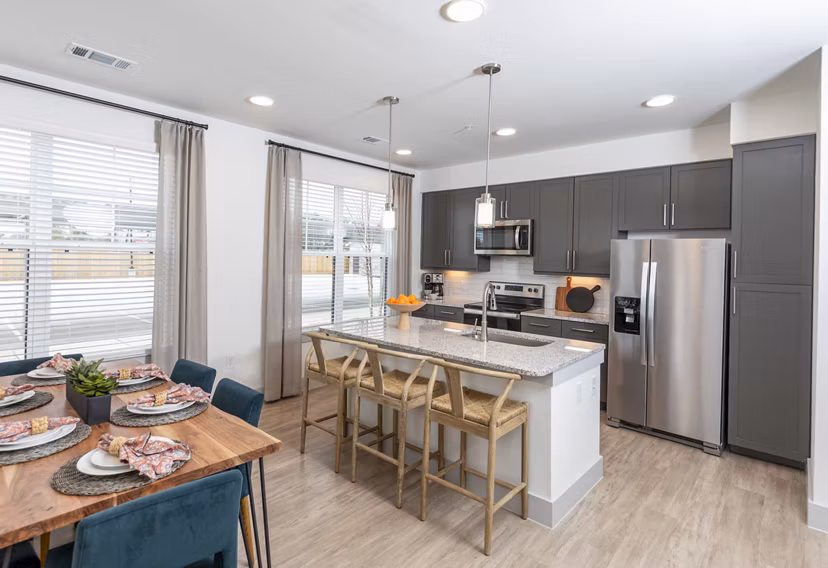 Modern kitchen and dining room with stainless steel appliances at The Madison at City Place Apartments