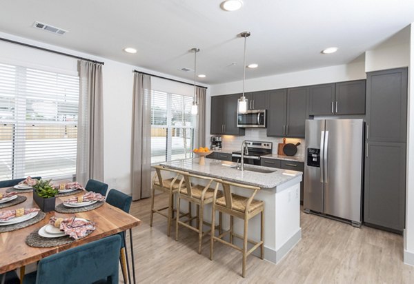 Modern kitchen and dining room with stainless steel appliances at The Madison at City Place Apartments