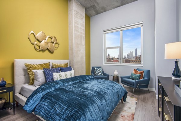 Cozy bedroom featuring modern decor and large windows in Spoke Apartments, Chicago