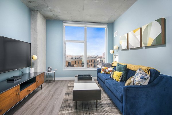 Inviting living room with modern decor and large windows at Spoke Apartments in Chicago