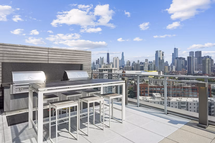 Outdoor grill area and patio with modern seating at Harvest Apartments, ideal for gatherings and relaxation