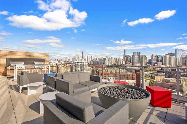 Fire pit and grill area on patio at Harvest Apartments: Luxurious outdoor amenities for relaxation and community gatherings