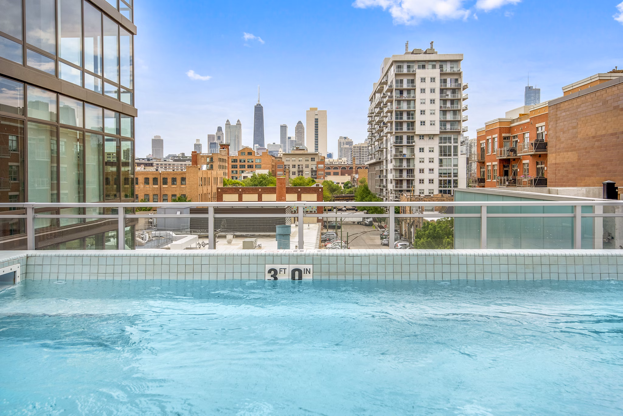 Sunlit outdoor pool area at Spoke Apartments with luxury lounges