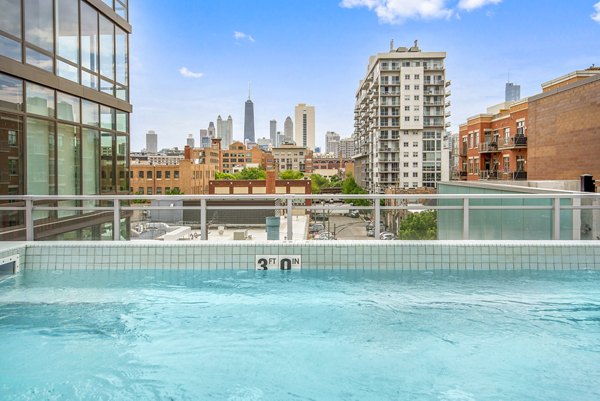 Sunlit outdoor pool area at Spoke Apartments with luxury lounges