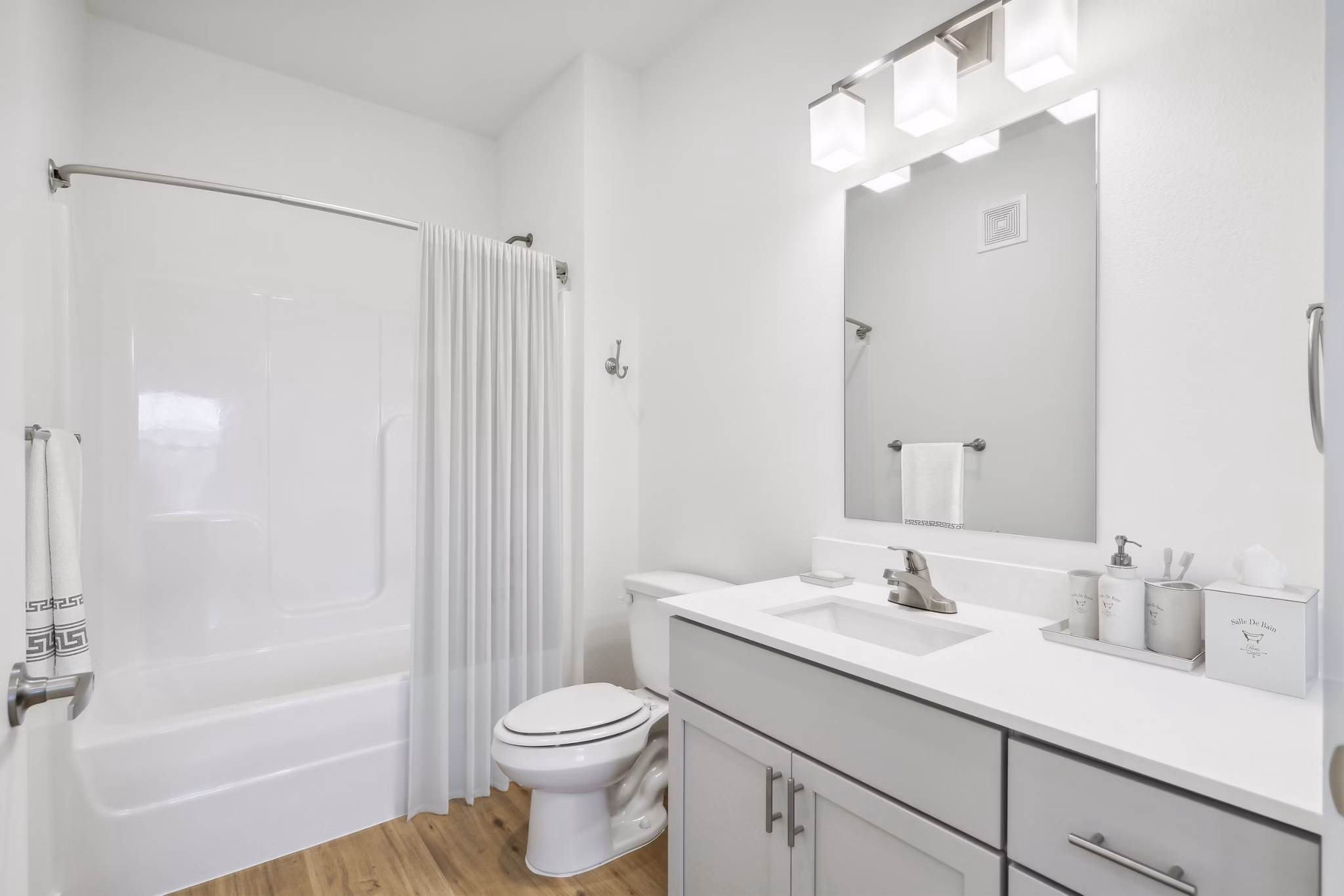 Elegant bathroom with modern fixtures at Pure OKC Apartments, featuring sleek countertops and spacious layout, offering a luxurious residential experience