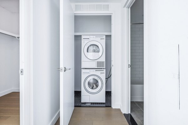 Laundry room featuring modern appliances at Embankment House Apartments