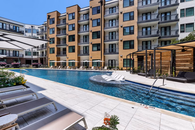 Modern pool area with poolside lounges at The Met Apartments