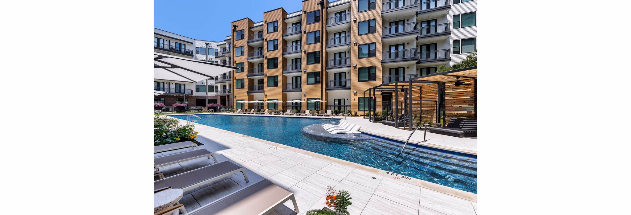 Modern pool area with poolside lounges at The Met Apartments