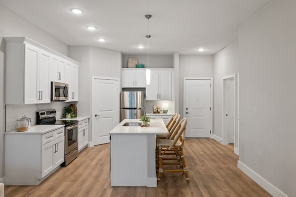 Kitchen featuring modern appliances and granite countertops in Encore at Tradition Apartments