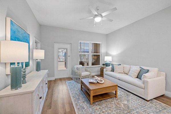 Elegant living room with modern furnishings and large windows at Encore at Tradition Apartments