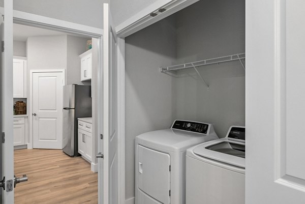 Laundry room with modern washers and dryers at Encore at Tradition Apartments