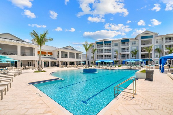 Resort-style pool with sun loungers at Encore at Tradition Apartments