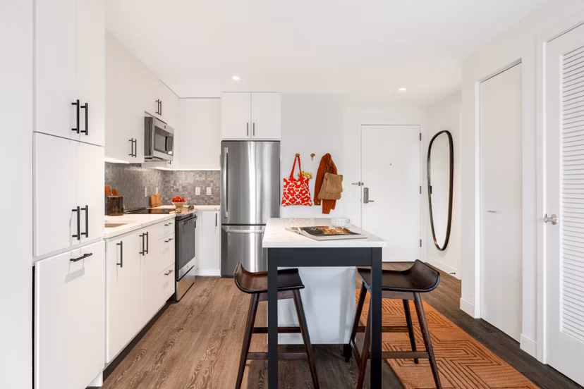 Modern kitchen with stainless steel appliances and quartz countertops at The Noble Apartments