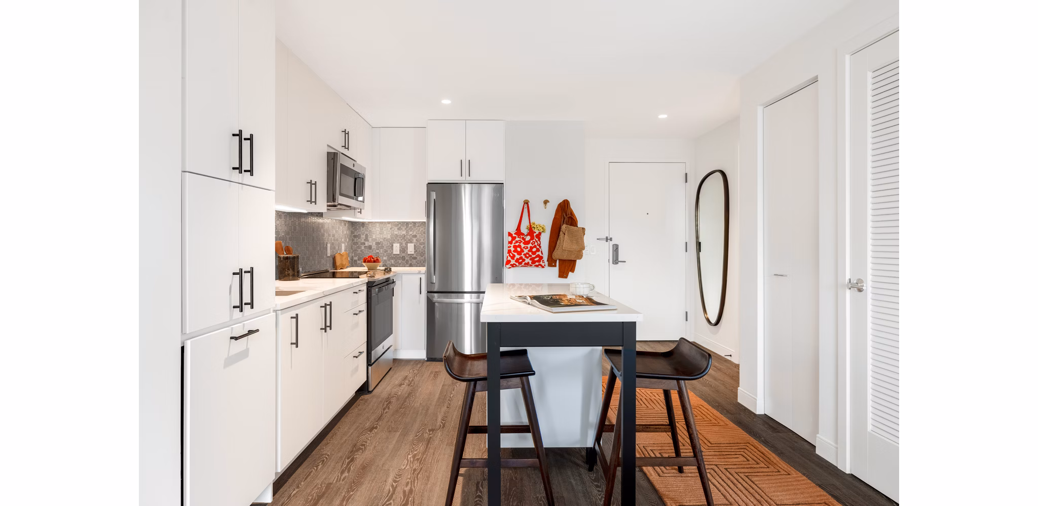 Modern kitchen with stainless steel appliances and quartz countertops at The Noble Apartments