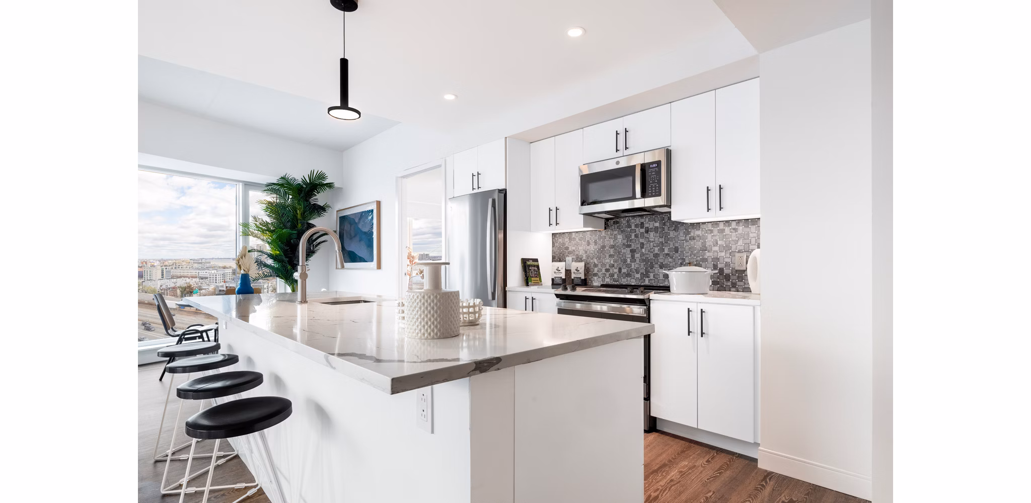 Modern kitchen with sleek countertops and stainless appliances in The Noble Apartments