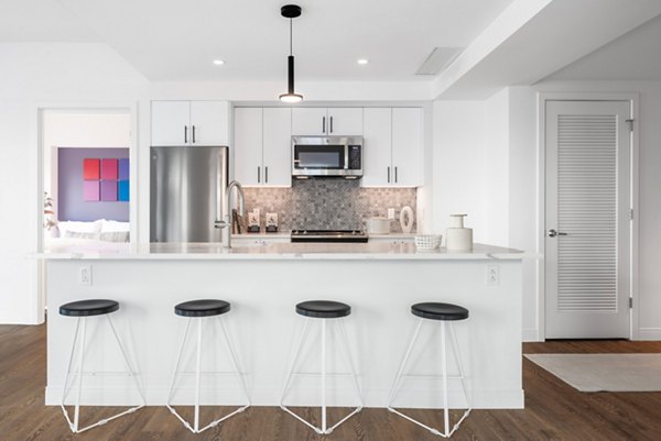 Modern kitchen with stainless steel appliances in The Noble Apartments, a luxurious Greystar community