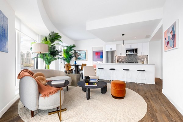 Living room with modern decor and natural lighting at The Noble Apartments