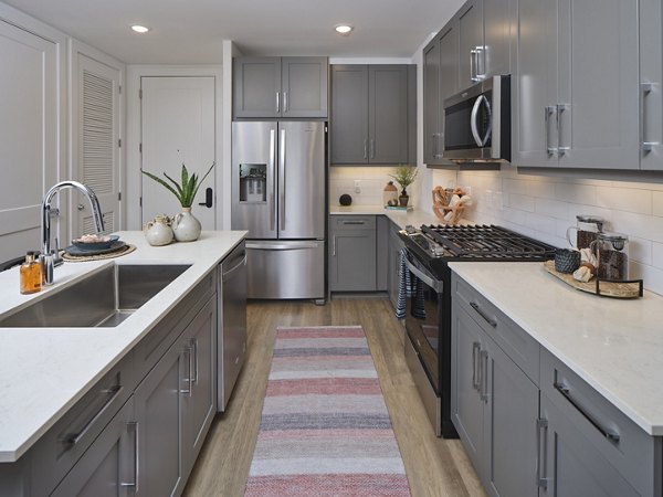 Modern kitchen with stainless steel appliances in The Eden at Lakeview Apartments