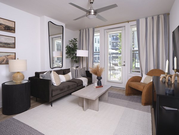 Spacious living room with modern decor and ample natural light in The Eden at Lakeview Apartments