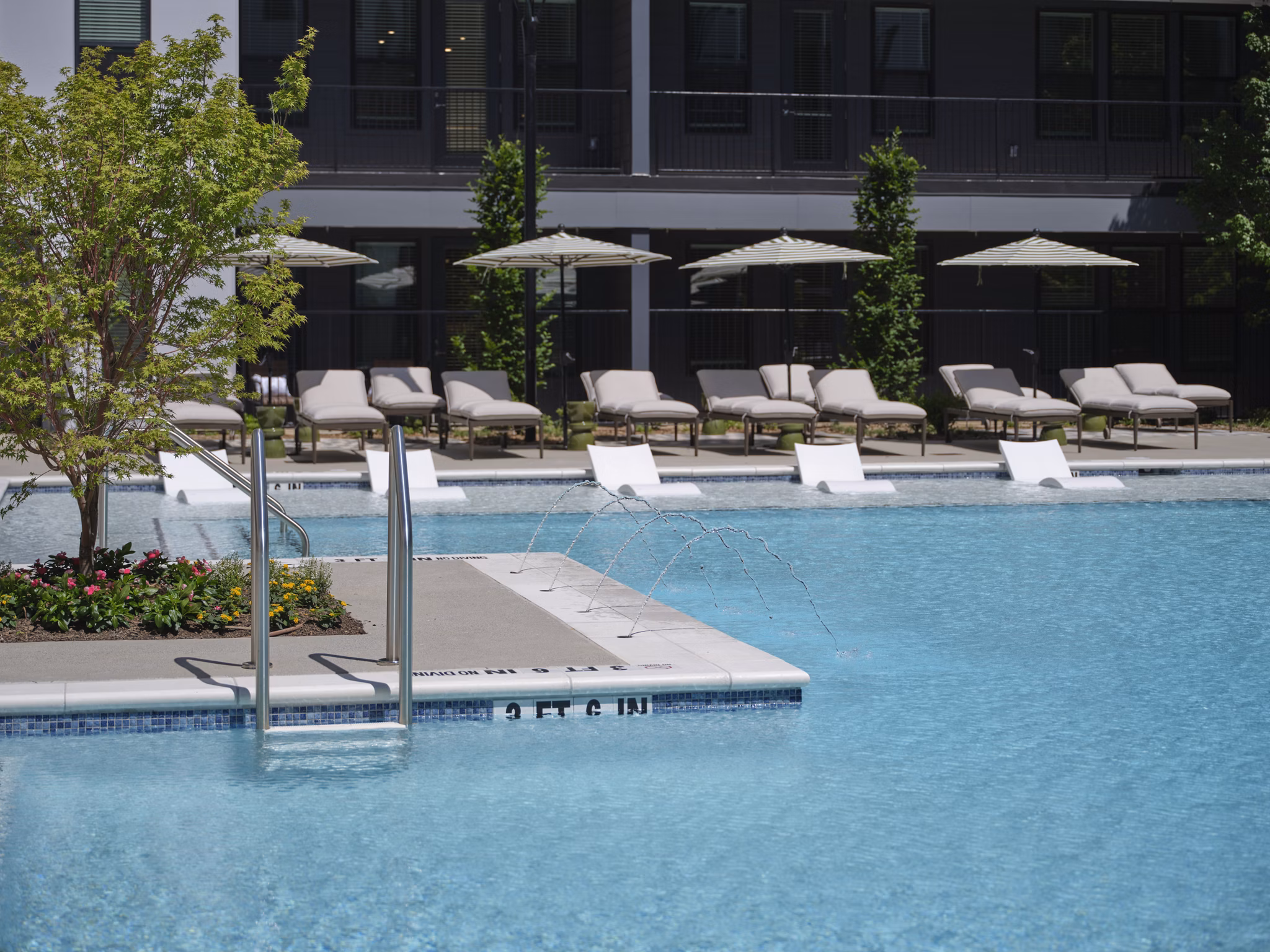 Infinity edge pool at The Eden at Lakeview Apartments with luxurious seating and lake views