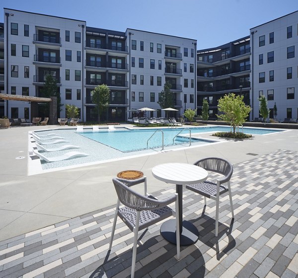 Poolside relaxation area at The Eden at Lakeview Apartments, offering luxurious seating and scenic views for residents