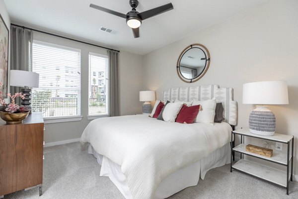 Modern bedroom with large windows and stylish decor at Eleve Apartments