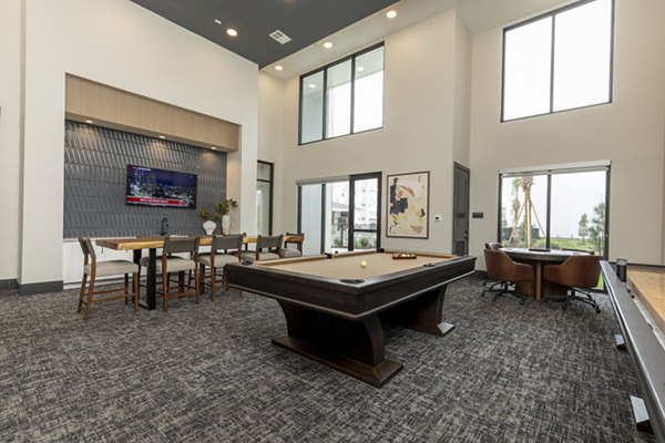 Modern gaming room with billiards and large screen TVs at Eleve Apartments, offering a luxury entertainment space in a vibrant community