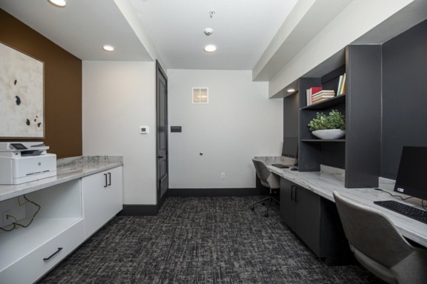Home office featuring ergonomic furniture and large windows at Eleve Apartments, luxury living ideal for remote work enthusiasts