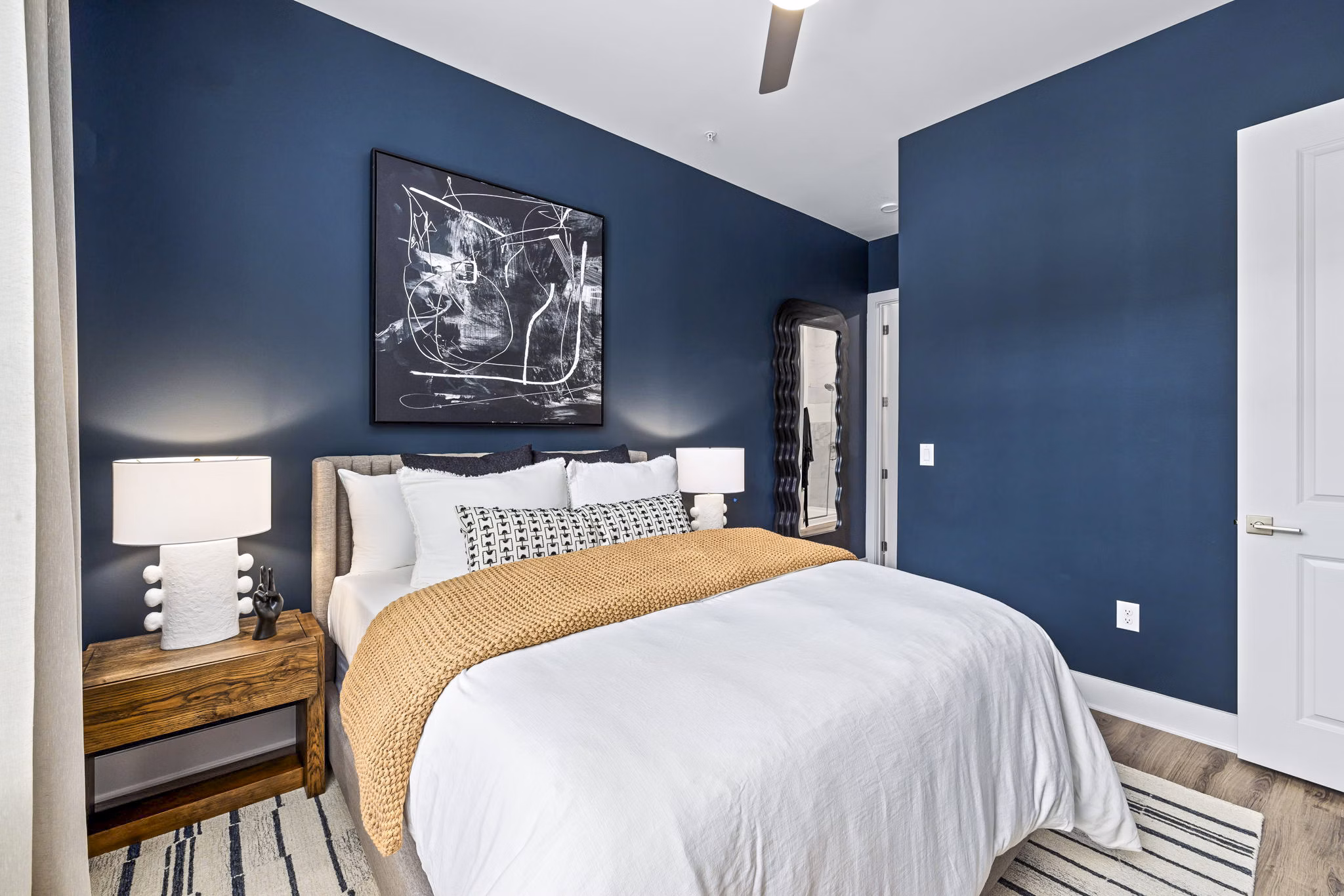 Bedroom featuring modern decor and large windows at The Keaton at Brier Creek Apartments
