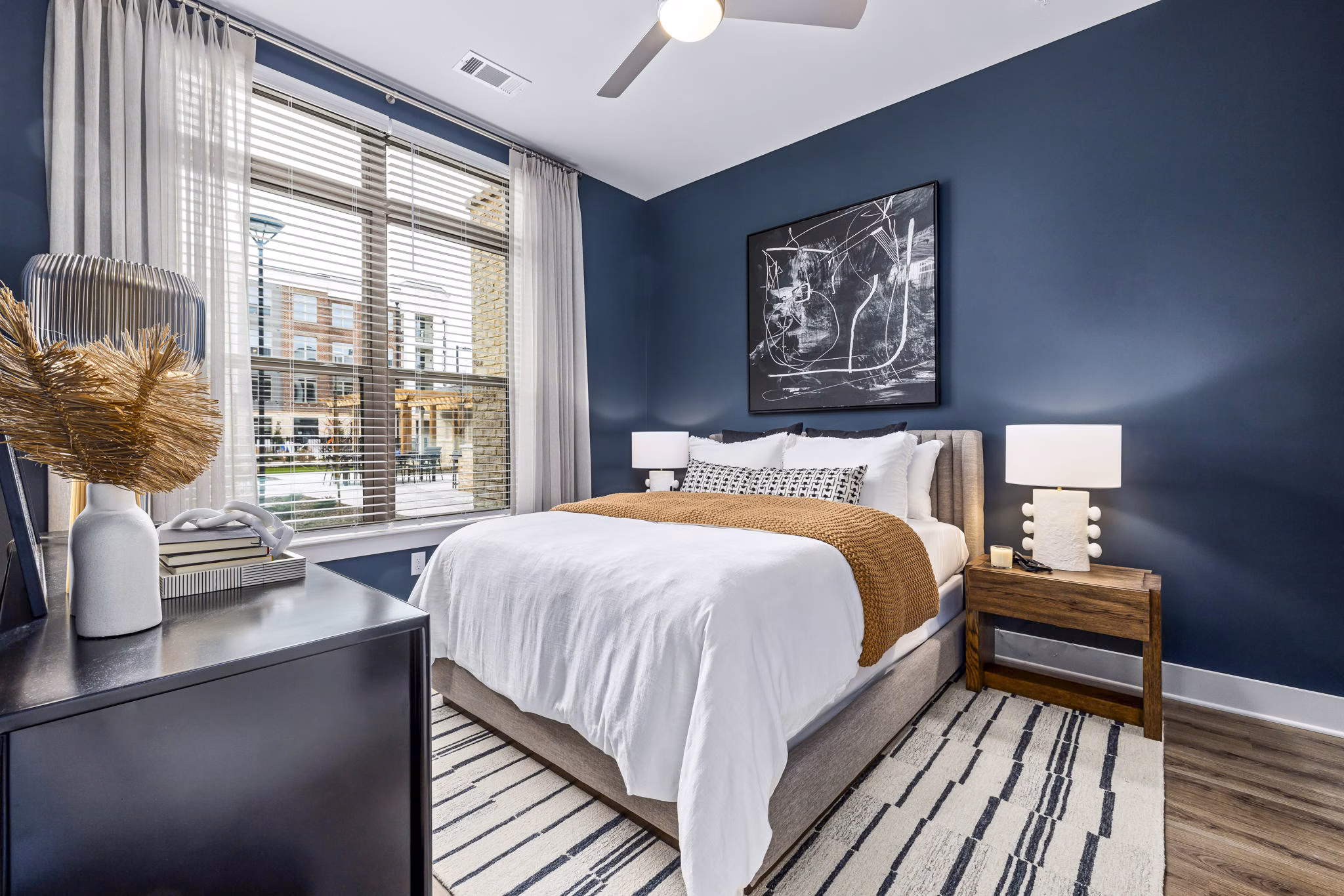 Bedroom with modern decor and ample natural light at The Keaton at Brier Creek Apartments