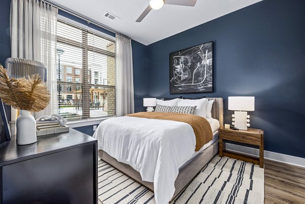 Bedroom with modern decor and ample natural light at The Keaton at Brier Creek Apartments