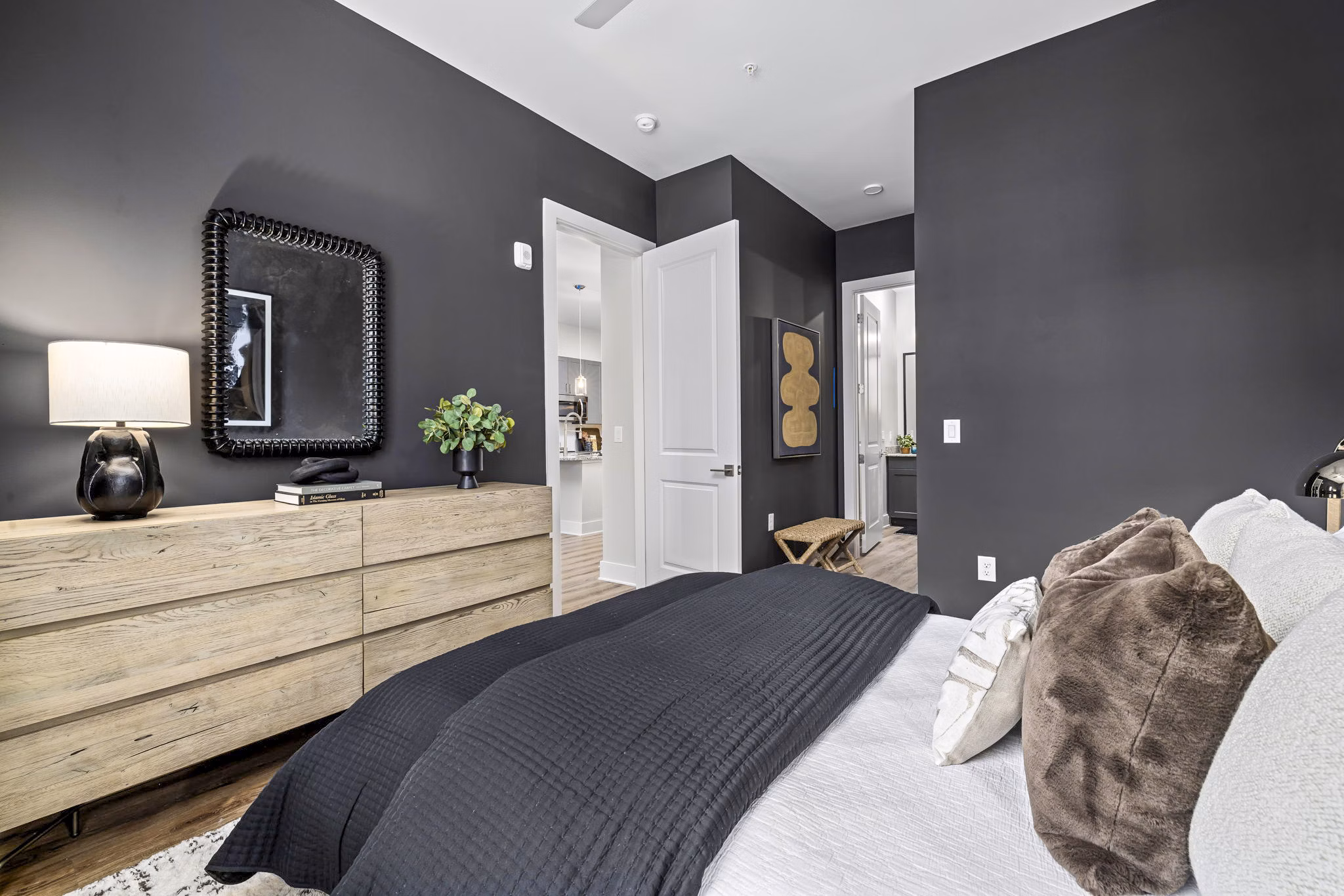 Bedroom featuring modern decor and plush bedding at The Keaton at Brier Creek Apartments