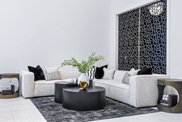 The Keaton at Brier Creek Apartments: Modern clubhouse lobby with cozy seating and bright lighting for social gatherings