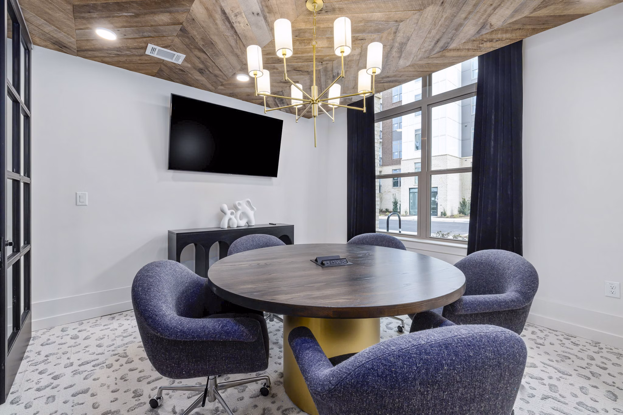 Clubhouse meeting facility with modern seating and audiovisual equipment at The Keaton at Brier Creek Apartments