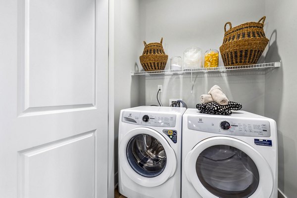 Laundry room featuring modern appliances in Keaton at Brier Creek Apartments