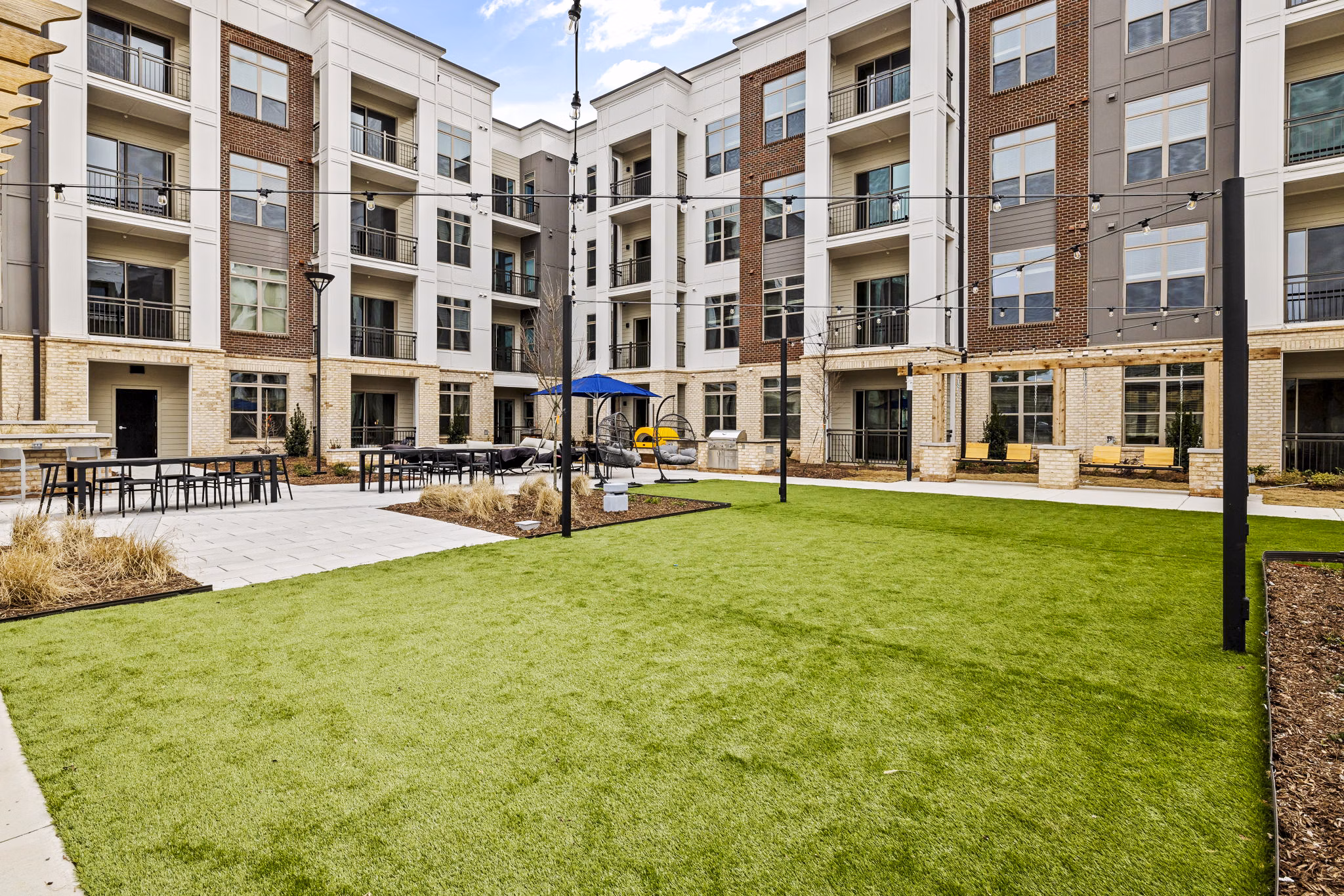 Dog park and patio at The Keaton at Brier Creek Apartments featuring pet-friendly spaces and outdoor seating