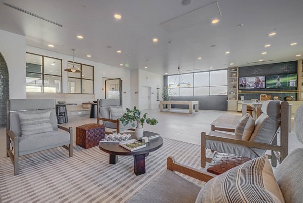 Modern clubhouse featuring cozy seating and large TV at Camber Apartments