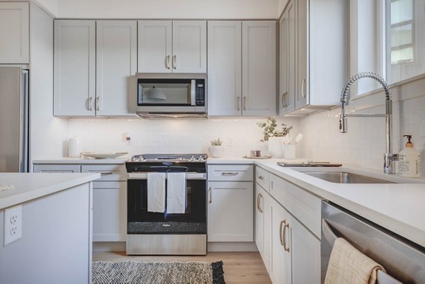 Modern kitchen with stainless steel appliances at Camber Apartments