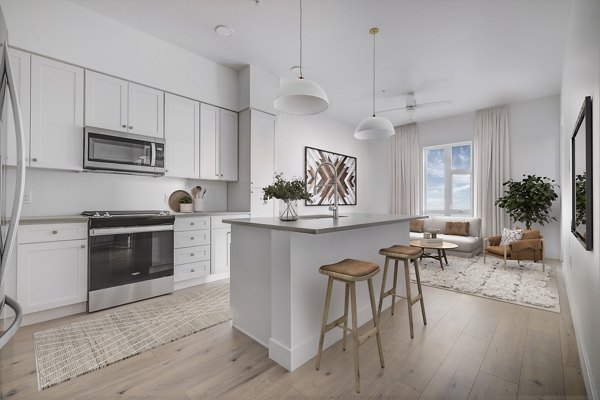 Modern kitchen with stainless steel appliances and granite countertops in Camber Apartments