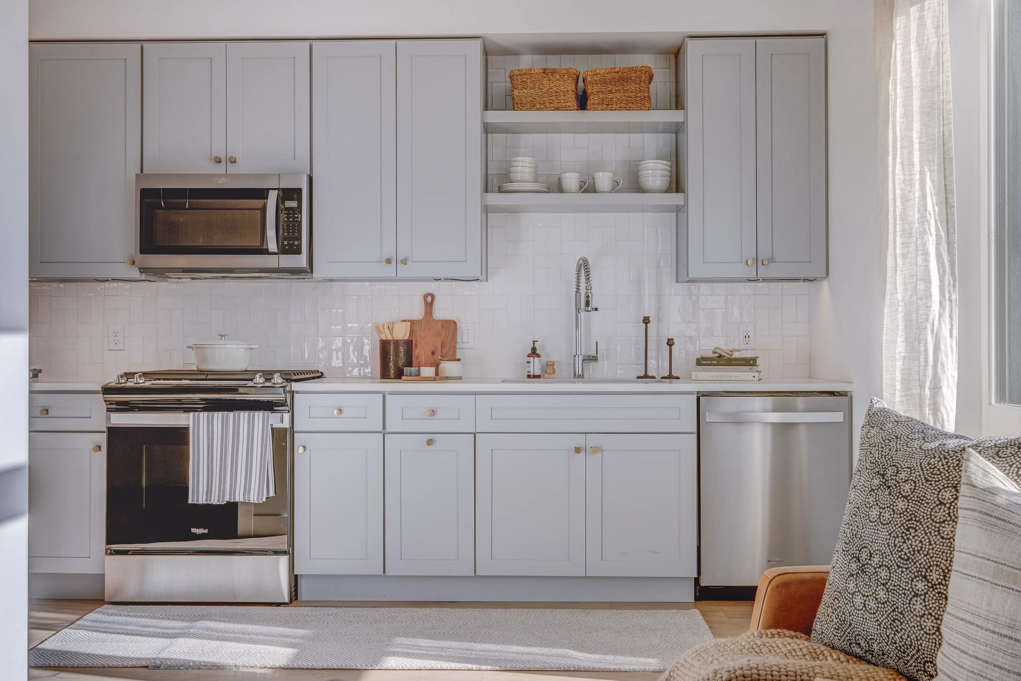 Modern kitchen with stainless steel appliances and quartz countertops in Camber Apartments