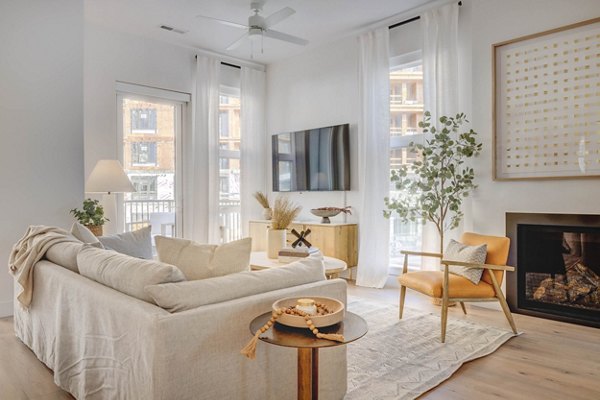 Spacious living room with modern decor and large windows at Camber Apartments