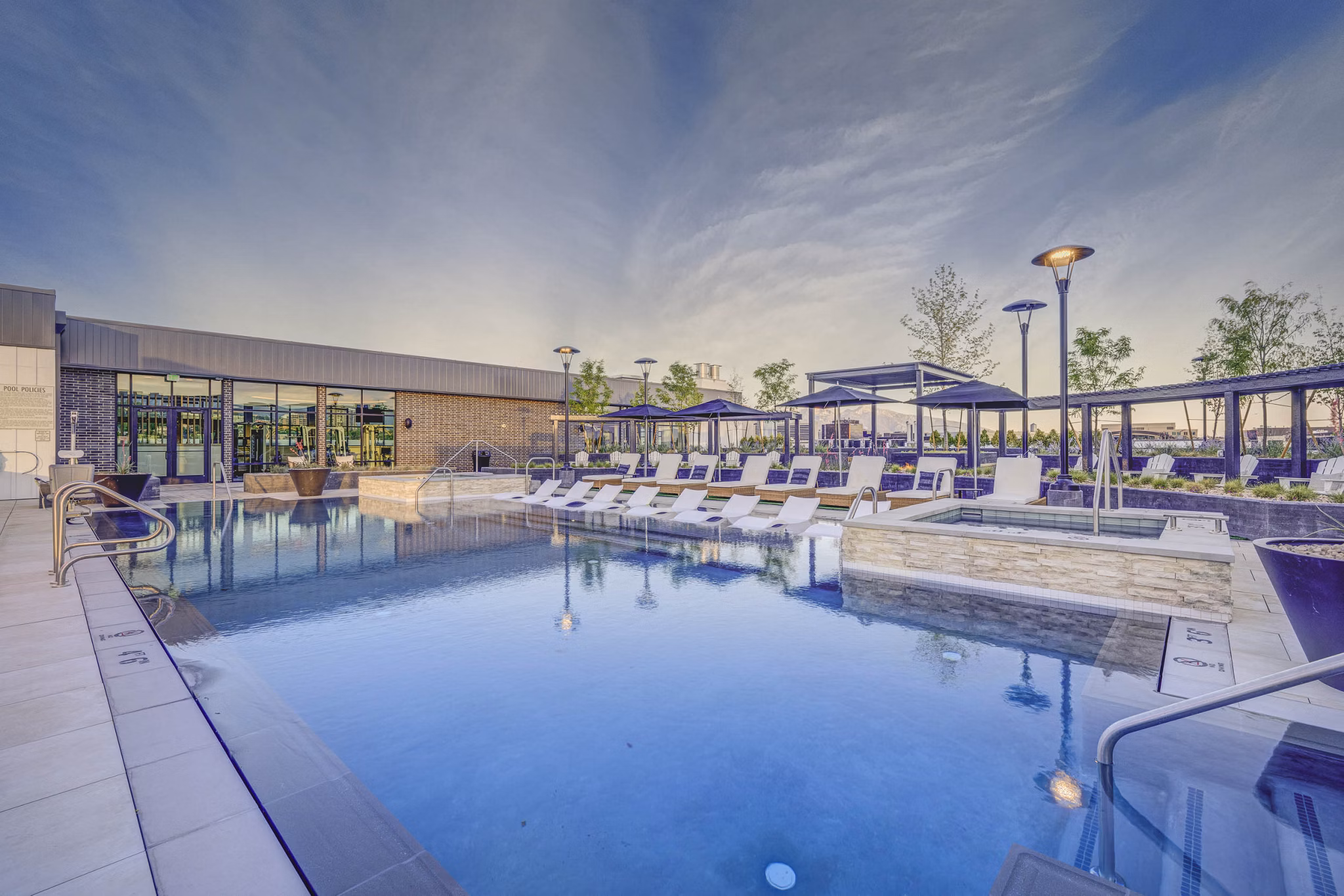 Resort-style pool with lush landscaping at Camber Apartments, offering luxury living amenities