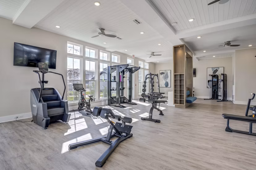 Fitness center with modern equipment at Alton Serenoa Apartments, featuring spacious workout areas and natural light