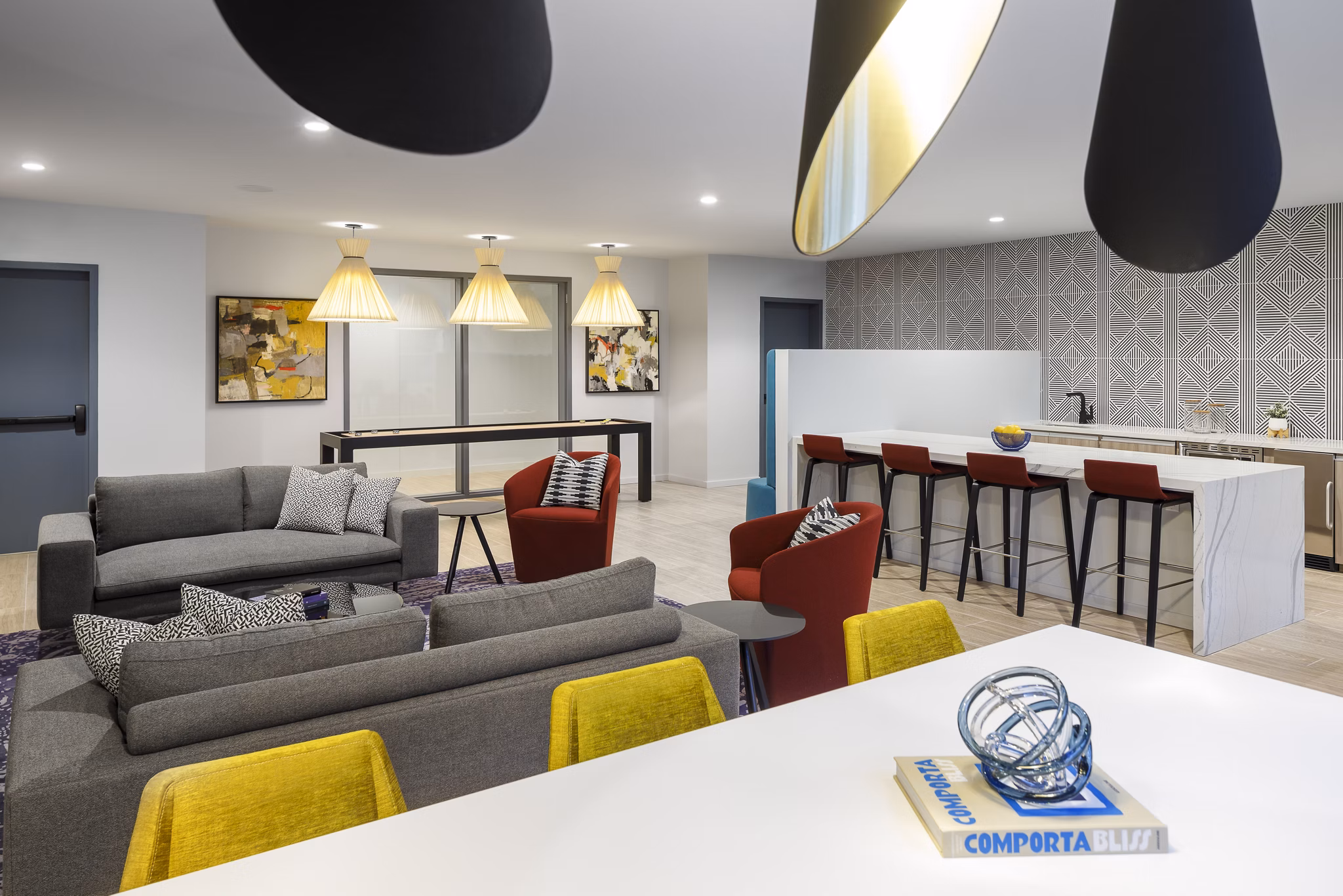 Modern clubhouse with cozy seating and communal workspaces at Atworth Apartments, a luxury community by Greystar